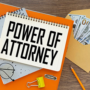 Notebook with 'Power of Attorney' text, next to an envelope with cash