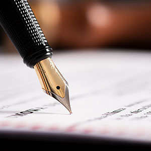 Close-up of a  pen signing a legal document, symbolizing wills